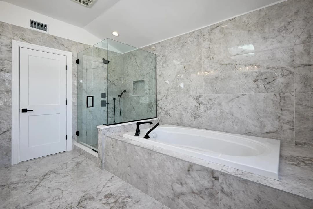 An elegant white freestanding bathtub with a stylish faucet.