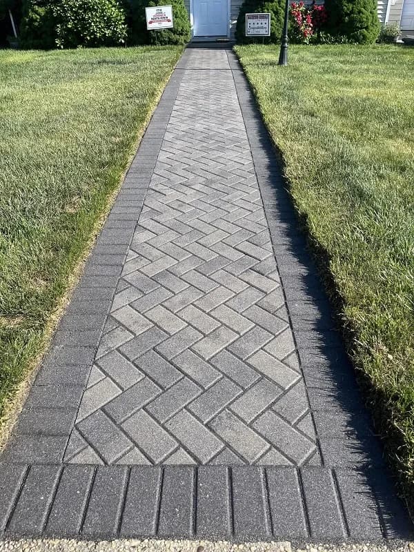 A front yard walkway made with decorative pavers.