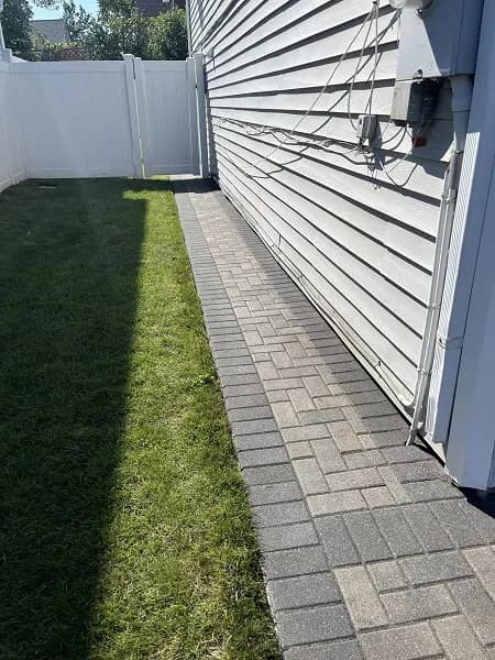 A side walkway leading to the backyard of a house.